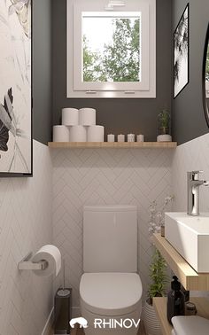 a white toilet sitting under a window next to a sink