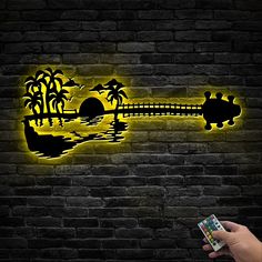 a hand holding a nintendo wii game controller in front of a brick wall with a neon sign