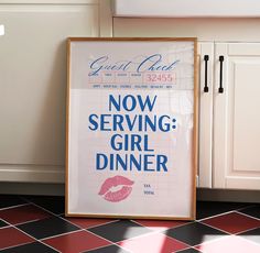 a poster is sitting on the floor in front of a kitchen counter with black and white tiles