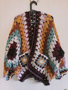 a crocheted jacket hanging on a hook