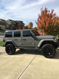 a gray jeep parked in front of a house