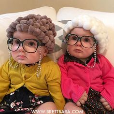 two small children sitting on top of a white couch wearing glasses and hair wigs