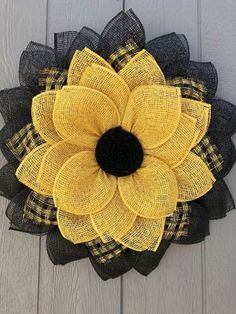 a yellow and black flower on the side of a building