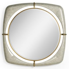 a mirror that is sitting on top of a white wall with gold trimmings