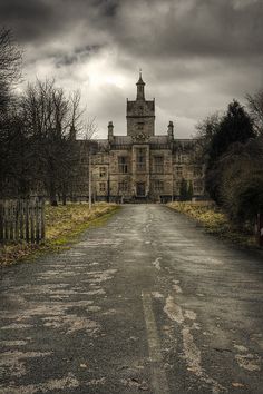 an old building with a large tower on the top and a long driveway leading to it