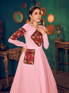 Look pretty adorning this pink color Anarkali gown in georgette material embellished with gamthi embroidery, mirror, and pearl work.
The gown comes with crepe inner material. 
The pink gown is semi-stitched can be customized up to 42 inches and the gown length is 58 inches. 
Pink color gown with gamthi work look amazing traditional can be worn at festivals like Navratri.
Disclaimer: This gown will not come with a can-can, bottom, and dupatta. Pink Embellished Kurta For Festivals, Pink Embellished Festival Kurta, Pink Kurta With Embroidered Border For Diwali, Pink Embroidered Kurta For Diwali, Pink Semi-stitched Embroidered Gown, Embellished Pink Georgette Kurta, Pink Anarkali Kurta With Mirror Work, Pink Embellished Georgette Kurta, Bollywood Style Pink Kurta With Embroidered Border