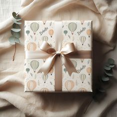 a present wrapped in white paper with a pink bow