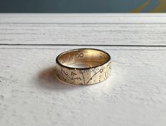 a close up of a gold ring on a white surface with the word go written in it