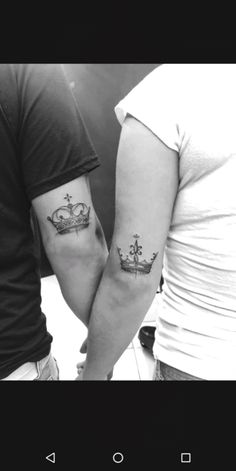 two people with tattoos on their arms, one is holding the other's hand