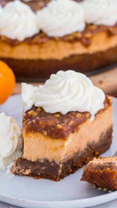 a slice of cheesecake on a plate with whipped cream and an orange in the background