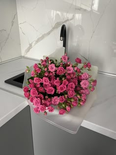 a bunch of pink roses sitting on top of a counter