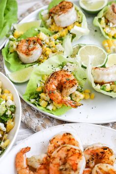 shrimp, corn and lettuce are served on white plates