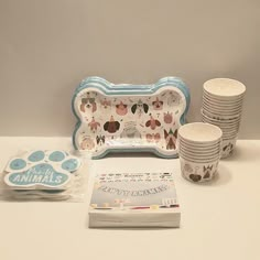 a table topped with plates and cups next to a nintendo wii game console controller system