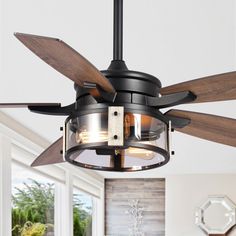 a ceiling fan that is hanging from the ceiling in a room with white walls and windows