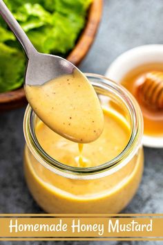 a spoon full of honey mustard next to a bowl of lettuce