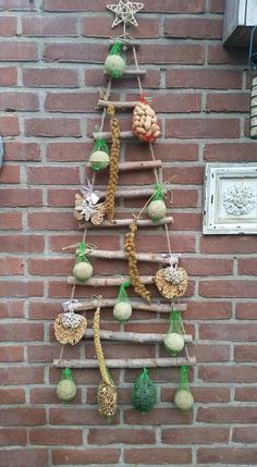 a christmas tree made out of ornaments hanging on a brick wall