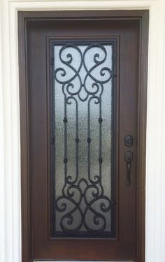 the front door is decorated with wrought iron bars and glass panels, along with a welcome mat