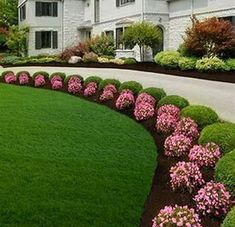 a large white house with lots of flowers in the front yard