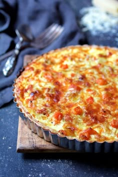 a quiche sitting on top of a wooden cutting board