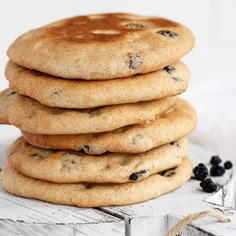 a stack of cookies sitting on top of a wooden table next to some blackberries