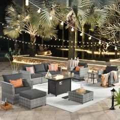 an outdoor seating area is lit up at night with string lights and palm trees in the background