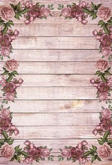 an old wooden background with pink roses and green leaves on the bottom half of it