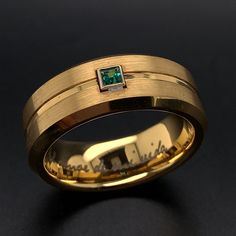 a gold ring with a green stone in the center