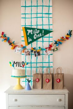 a table topped with bags and pictures next to a wall hanging on the side of a wall