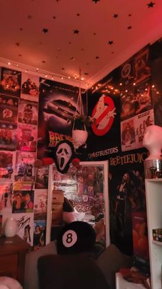 a room filled with posters and lights on the wall next to a bed in front of a window