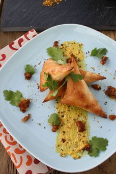 a white plate topped with food and garnishes on top of a wooden table