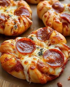 several pepperoni pizzas sitting on top of a cutting board