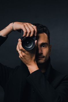 a man holding up a camera to take a selfie with his hand and looking at the camera