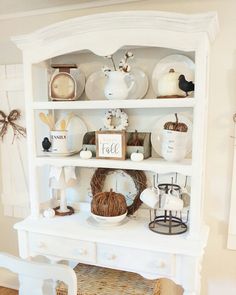 a white hutch with pumpkins and other items on it