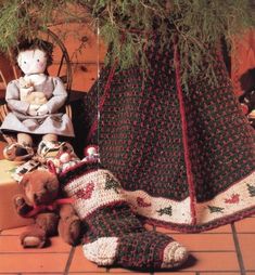 two stuffed animals sitting under a tree next to knitted stockings