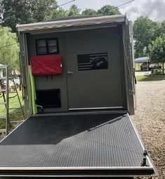 the back of a trailer with its door open and an american flag on it's side