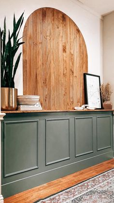 a living room with wood paneling and a plant on the shelf next to it