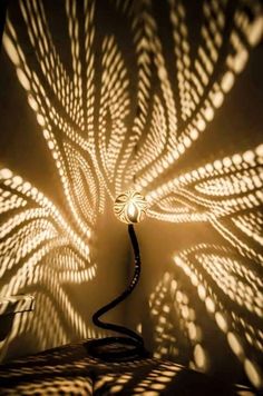 a lamp that is sitting on top of a table next to a wall with shadows