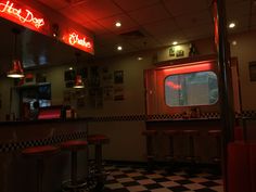 the interior of a diner with red neon lights