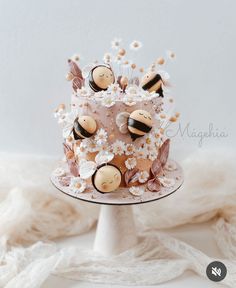 a cake decorated with flowers and bees on a plate