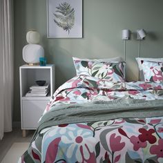 a bedroom with green walls and floral bedding