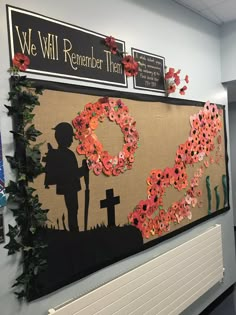 a bulletin board is decorated with flowers and wreaths on the wall next to a cross