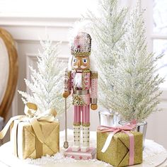 a nutcracker figurine sitting on top of a table next to presents