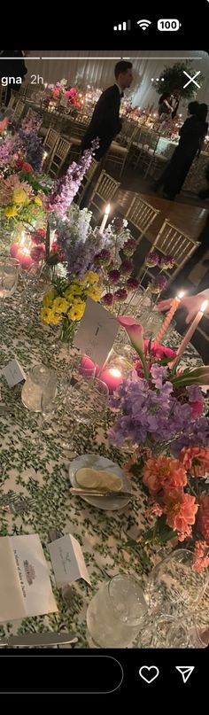 the table is covered with flowers and cards for guests to write in their place settings