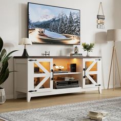 a living room scene with focus on the entertainment center and large screen television mounted to the wall