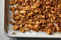 a metal tray filled with granola on top of a table