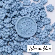 some blue flowers and a button with the word warnn glue on it's side