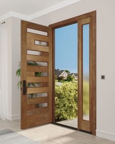 an open wooden door in a white room with wood flooring and windows looking out onto a green landscape