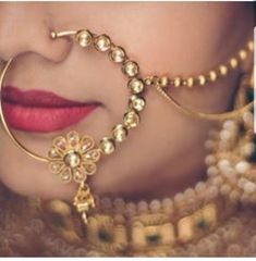 a close up of a woman's face with jewelry on her neck and nose