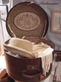 an open suitcase sitting on top of a table next to a white towel and hat