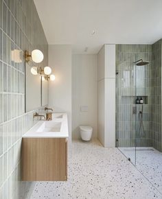 a bathroom with two sinks, a toilet and a walk in shower stall next to each other